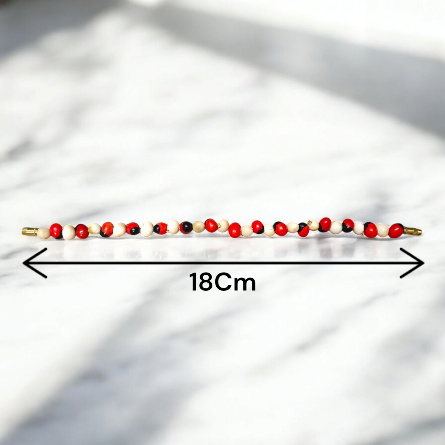 Natural Red and White Gunja bracelet with 5mm lab certified beads on stretchable cord, displayed on a neutral background