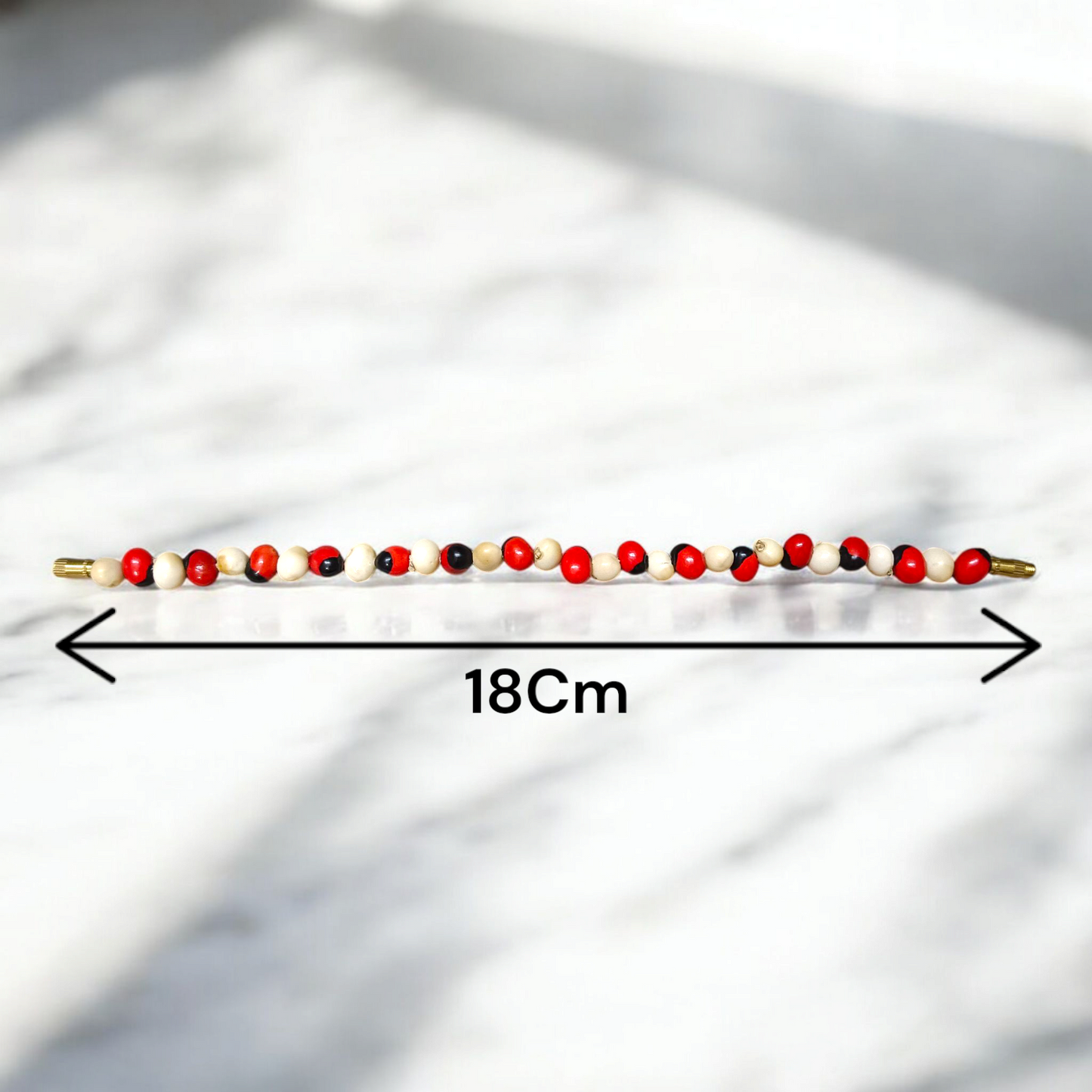Natural Red and White Gunja bracelet with 5mm lab certified beads on stretchable cord, displayed on a neutral background