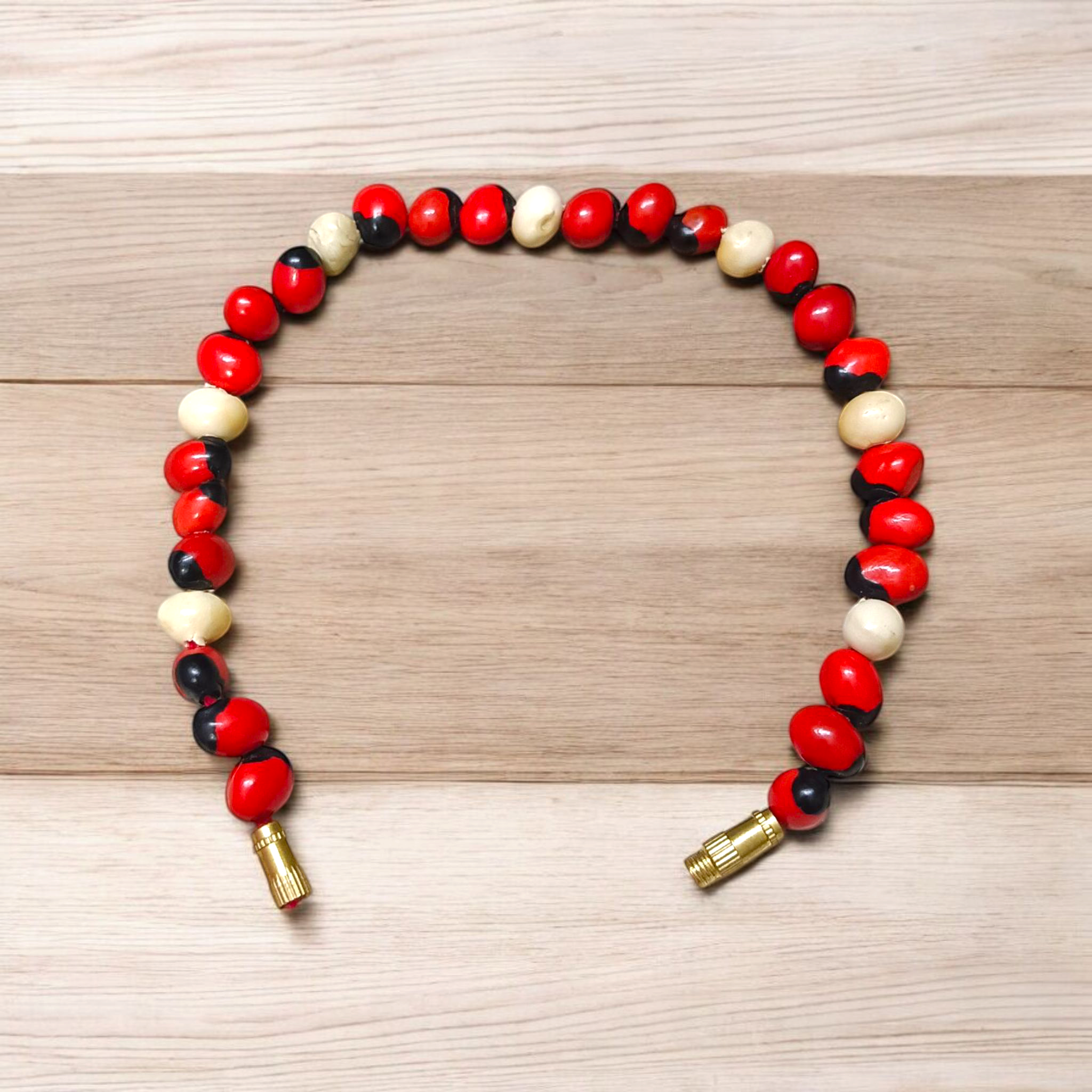 Natural Red and White Gunja seed bracelet with approx. 5mm beads, stretchable and lab certified, displayed on a white background
