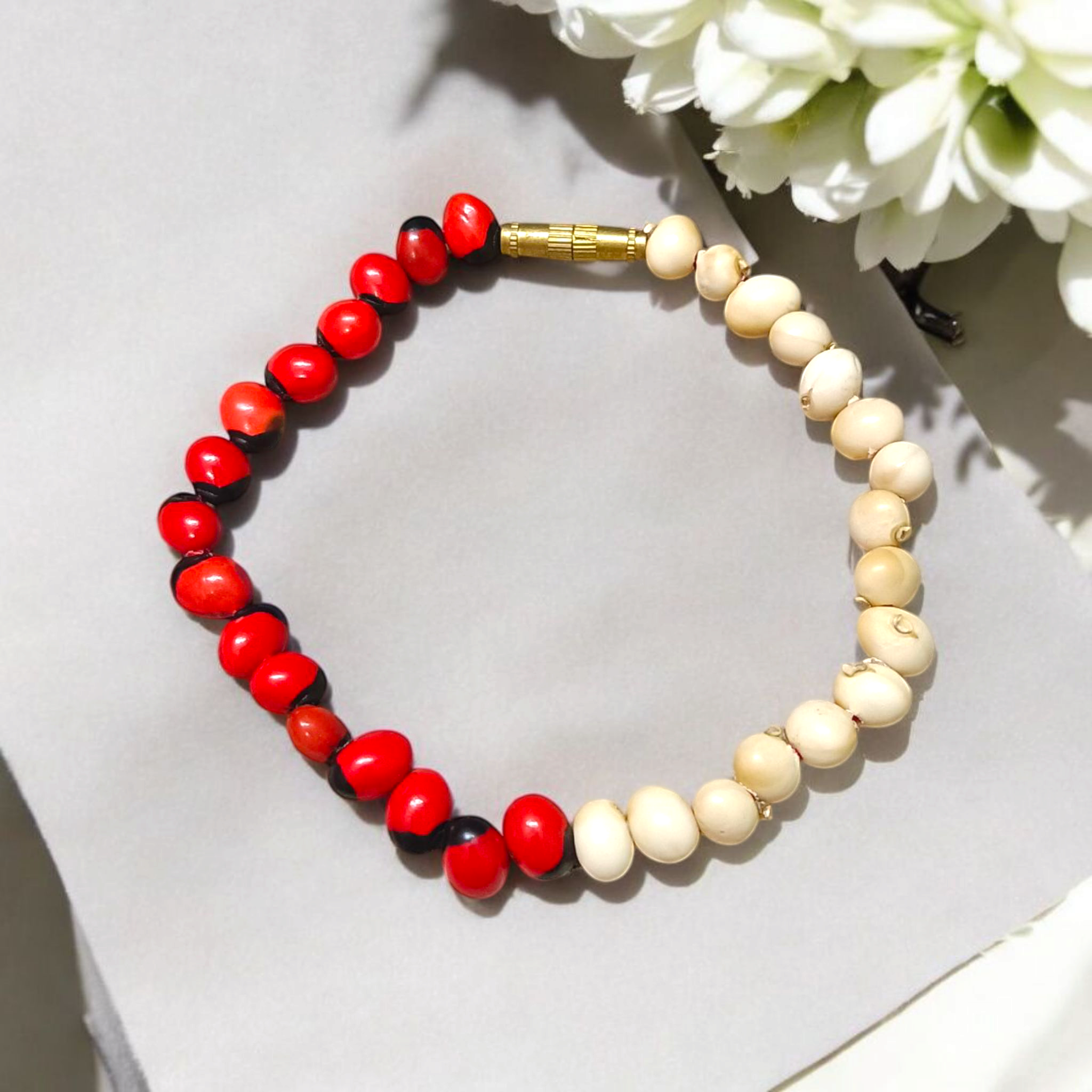 Natural Red and White Gunja seed bracelet with approx. 5mm beads, stretchable and lab certified, displayed on a white background