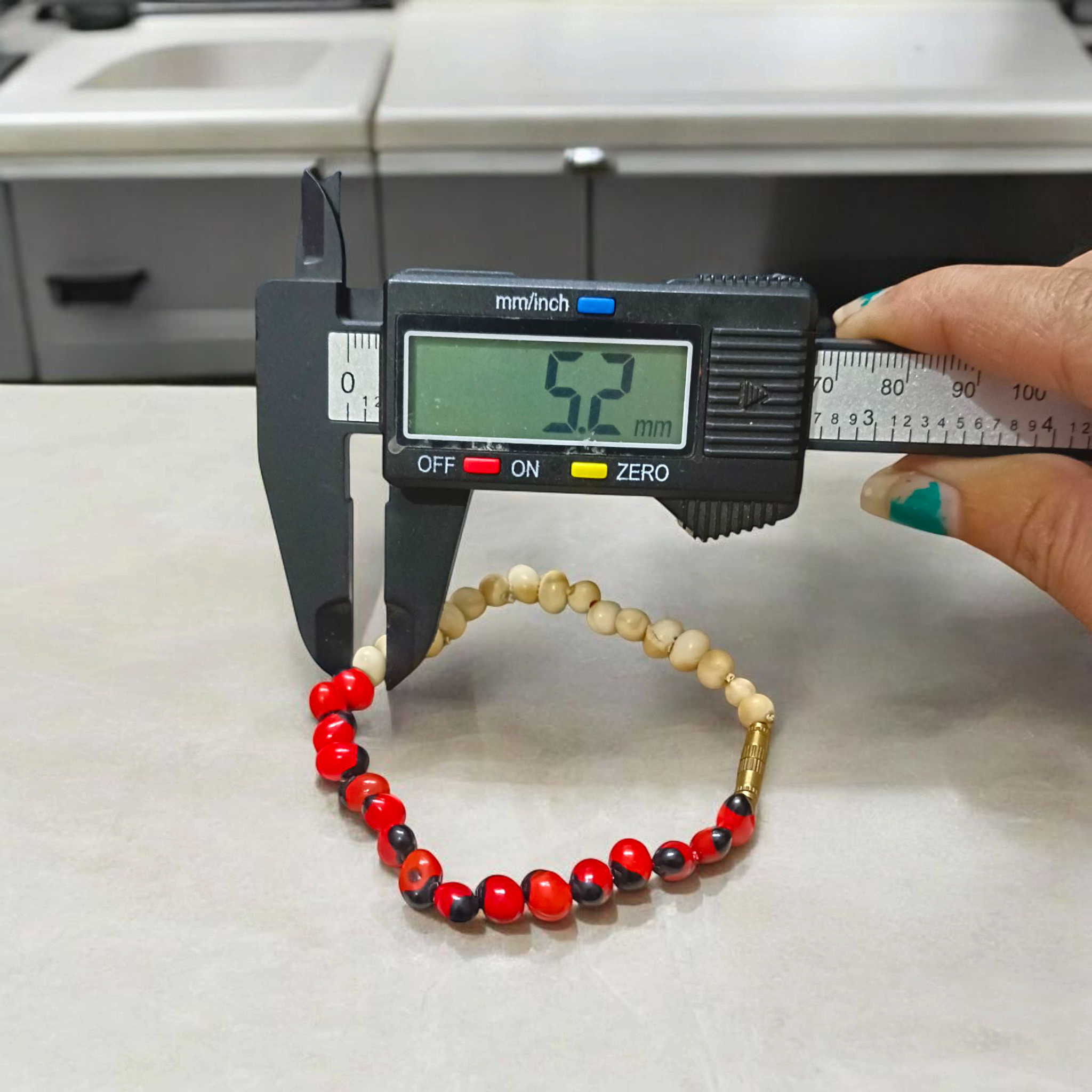 Natural Red and White Gunja seed bracelet with approx. 5mm beads, stretchable and lab certified, displayed on a white background