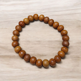 Natural White Sandalwood Bracelet with 8mm round stretchable beads, lab certified, displayed on a wooden surface