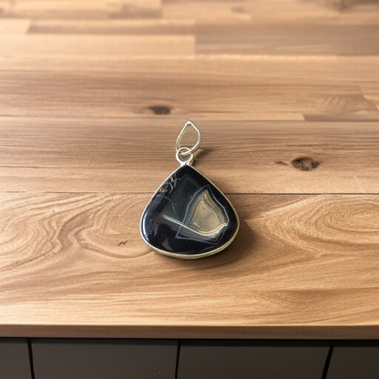 Natural lab certified Sulemani Hakik pendant with black and grey bands, fitted in a wearable setting for healing and protection