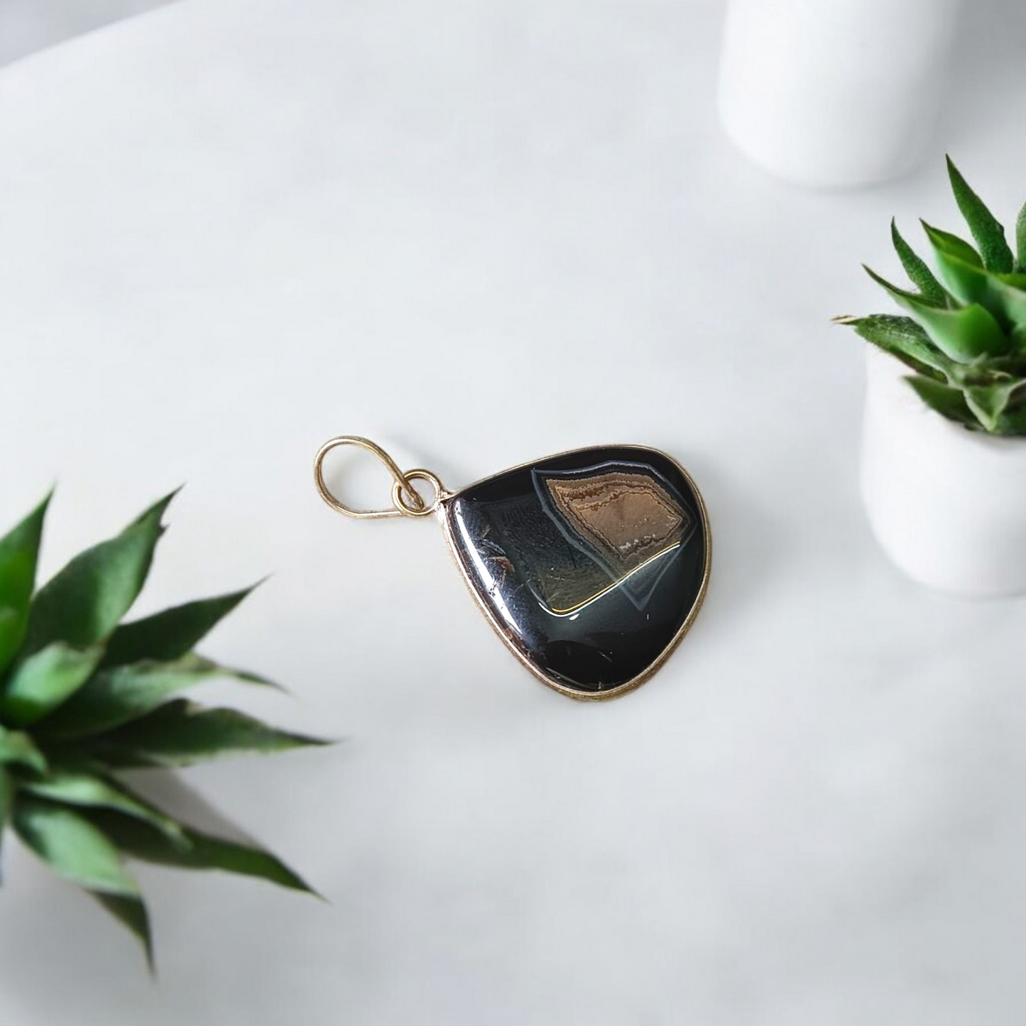 Natural lab certified Sulemani Hakik pendant with black and grey bands, fitted in a wearable setting for healing and protection