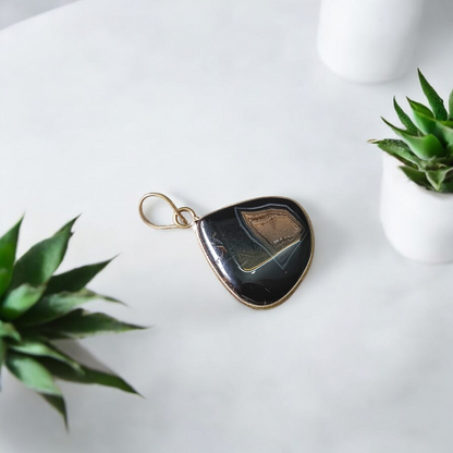 Natural lab certified Sulemani Hakik pendant with black and grey bands, fitted in a wearable setting for healing and protection