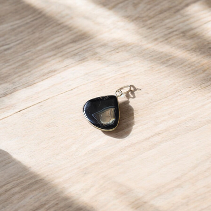 Natural lab certified Sulemani Hakik pendant with black and grey bands, fitted in a wearable setting for healing and protection