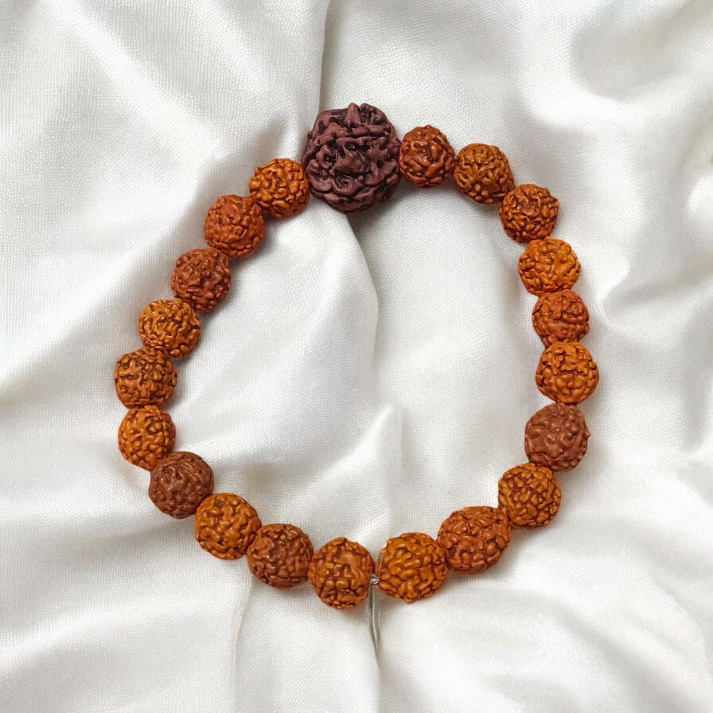 Original 5 Face Rudraksha Bracelet made with AAA Grade handpicked beads, stretchable and lab certified, placed on a rustic wooden surface