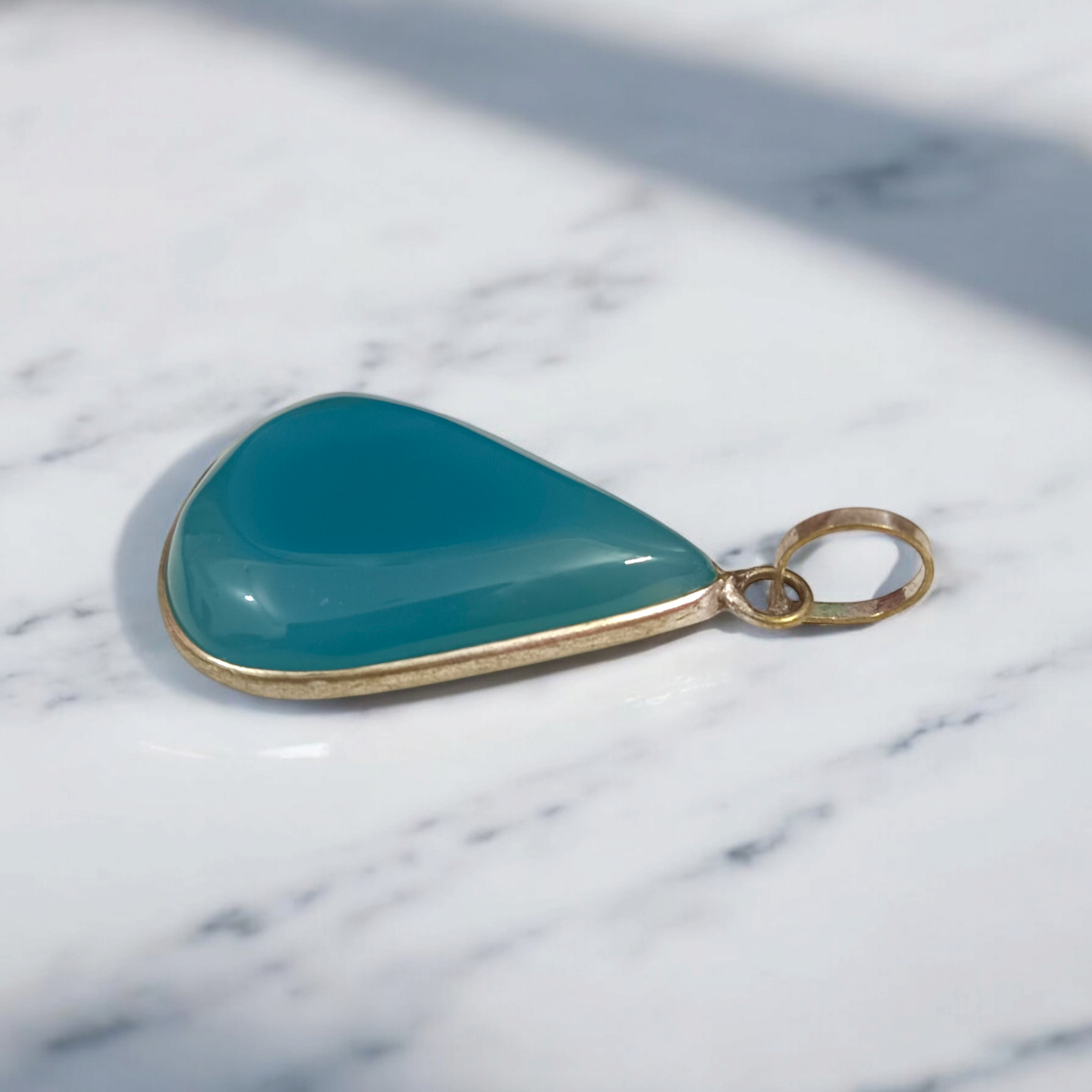 Original Firoza pendant with a vibrant turquoise hue, displayed on a necklace, highlighting its polished finish and elegant design.