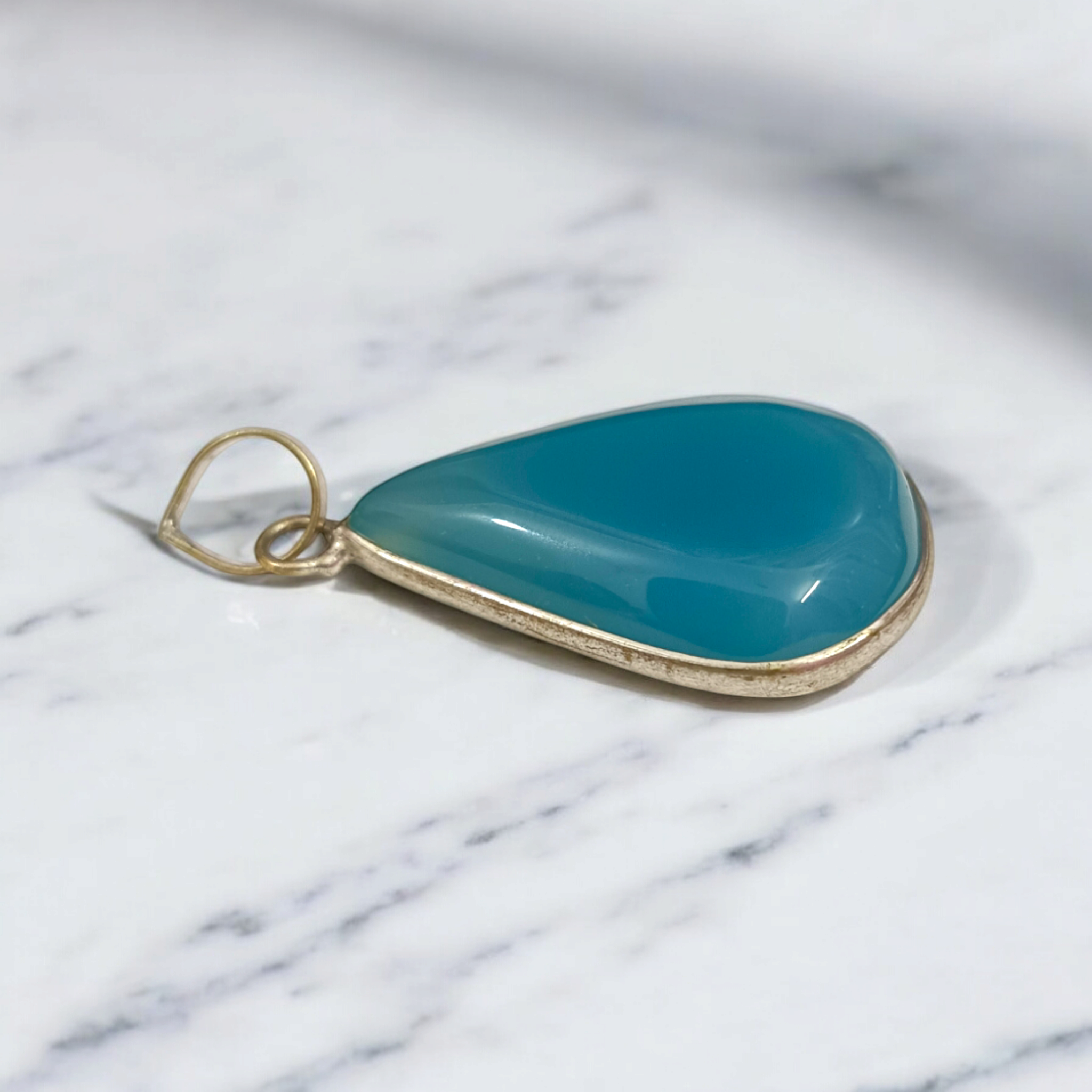 Original Firoza pendant with a vibrant turquoise hue, displayed on a necklace, highlighting its polished finish and elegant design.