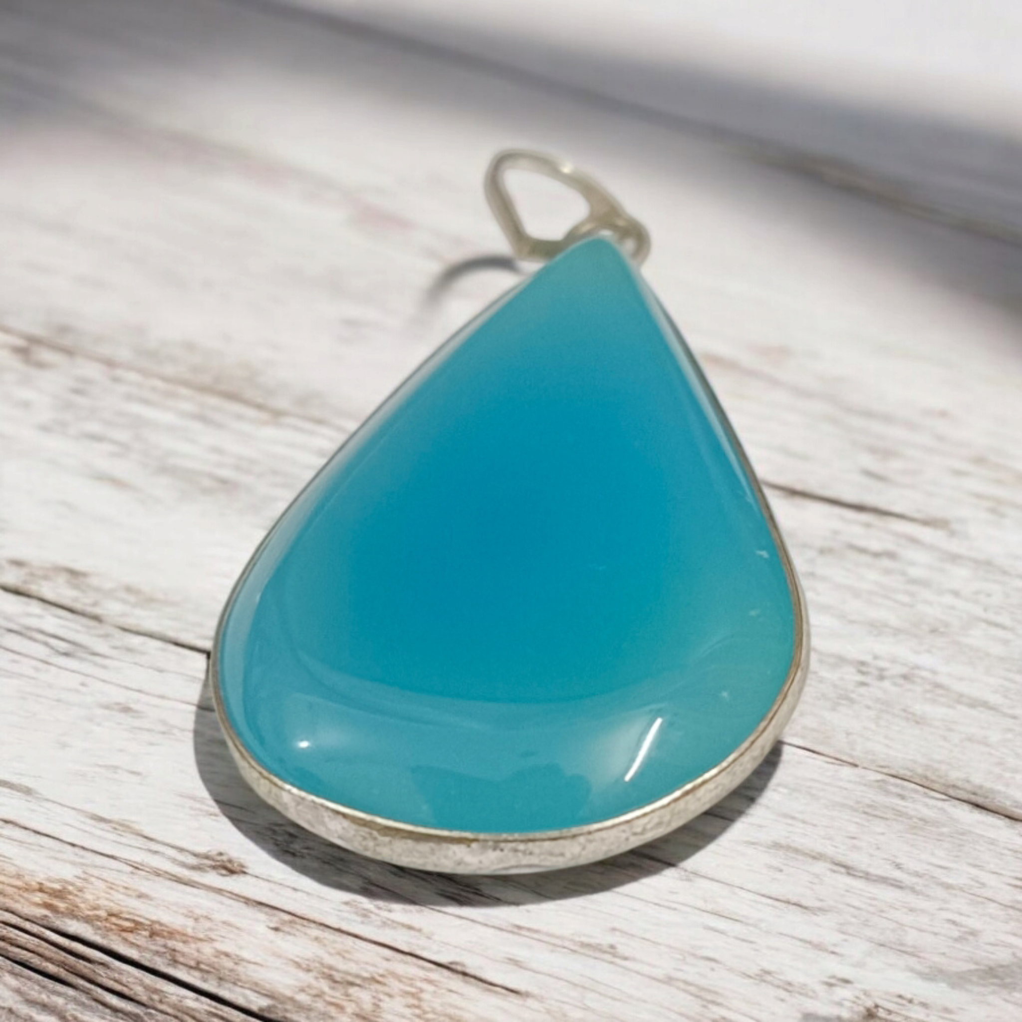 Original Firoza pendant with a vibrant turquoise hue, displayed on a necklace, highlighting its polished finish and elegant design.