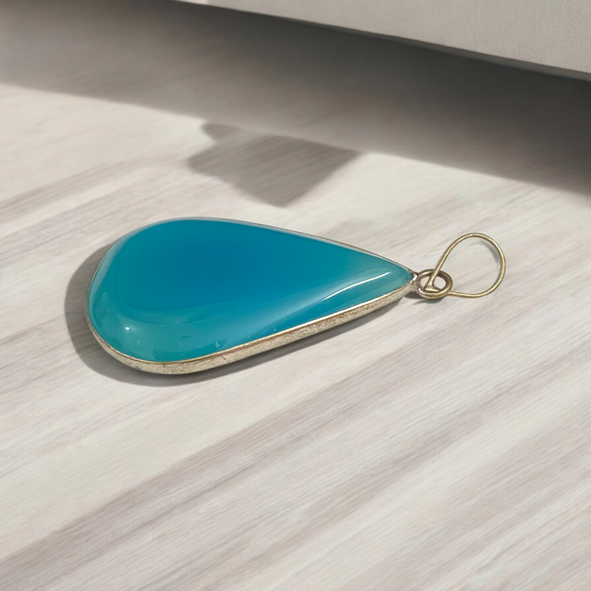 Original Firoza pendant with a vibrant turquoise hue, displayed on a necklace, highlighting its polished finish and elegant design.