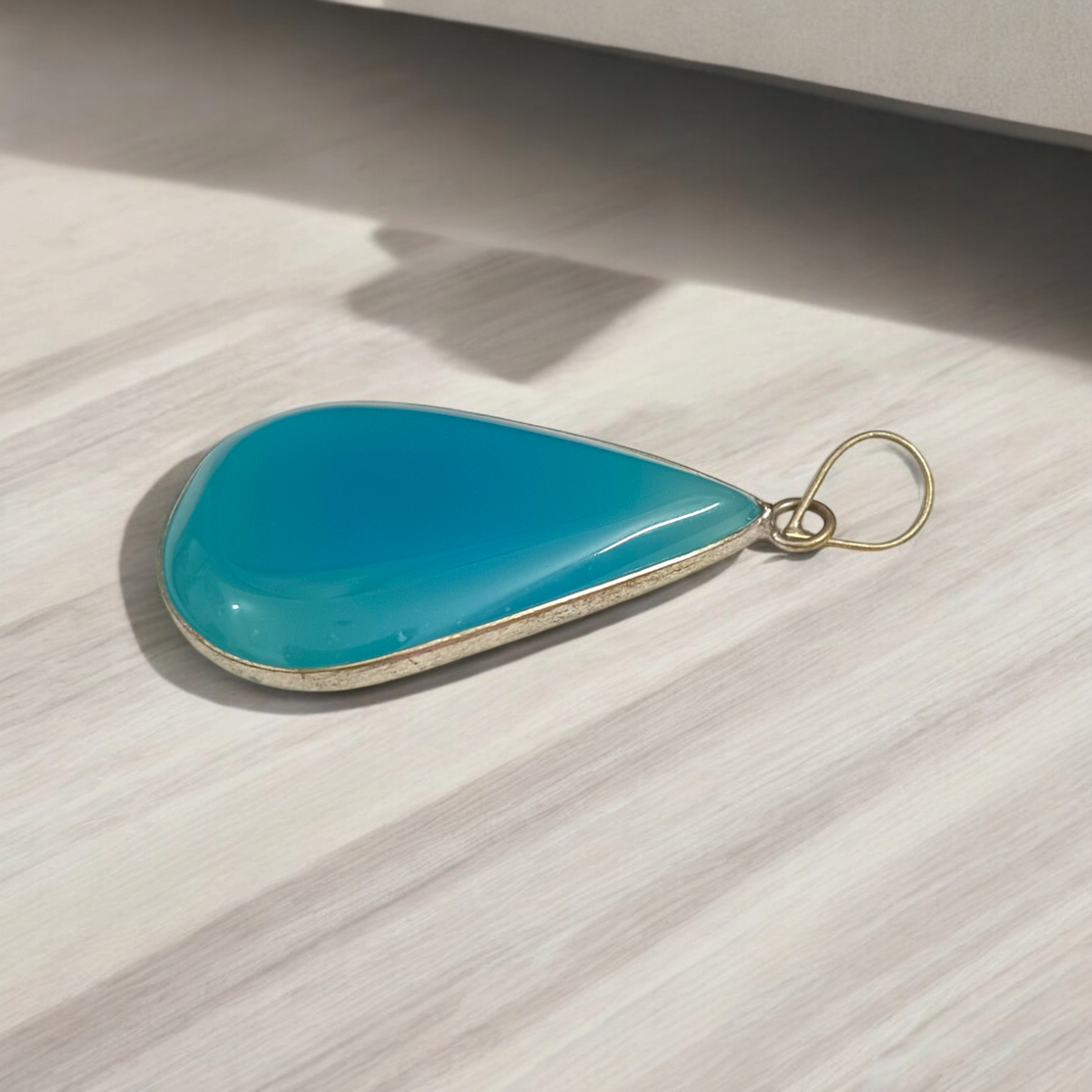 Original Firoza pendant with a vibrant turquoise hue, displayed on a necklace, highlighting its polished finish and elegant design.