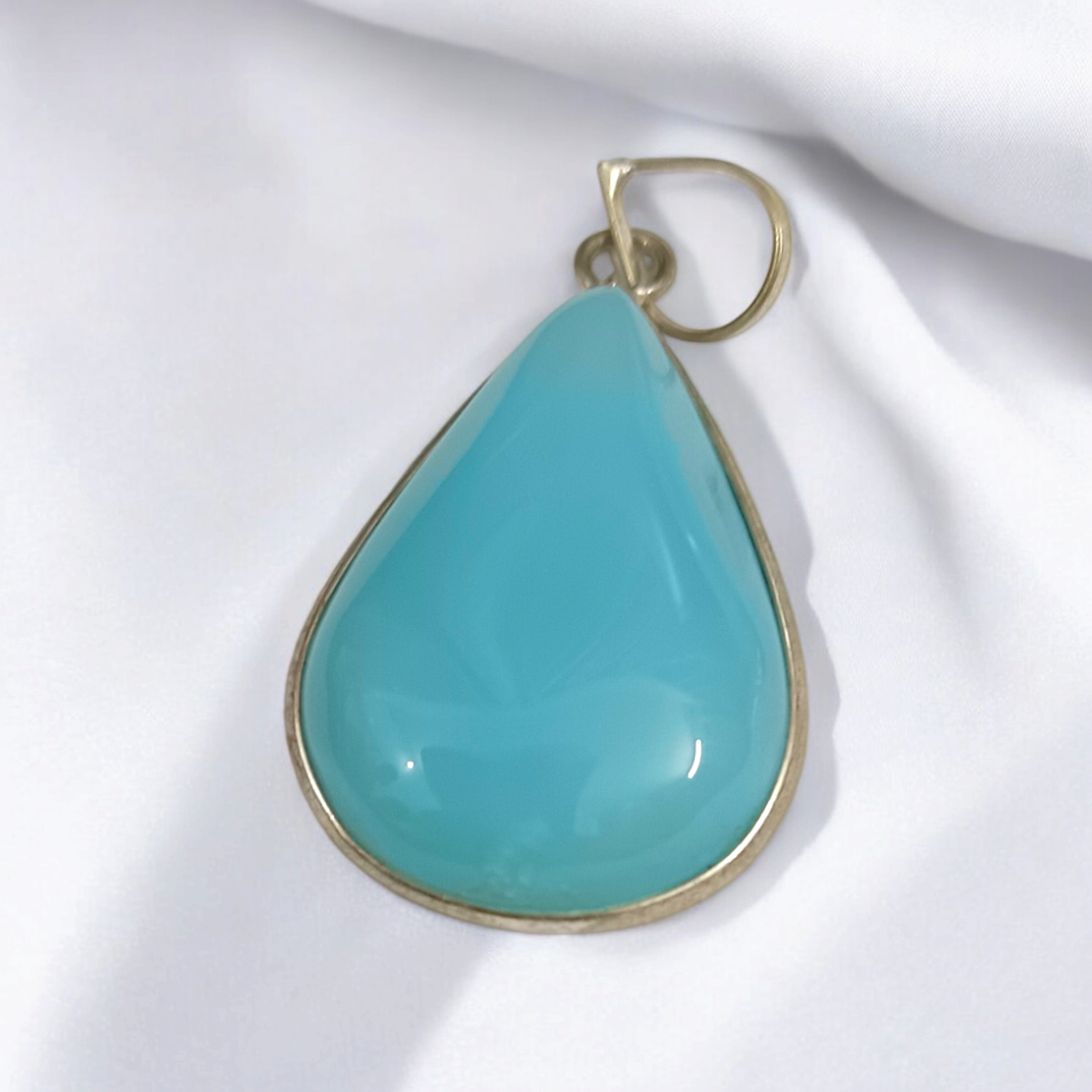 Original Firoza pendant with a vibrant turquoise hue, displayed on a necklace, highlighting its polished finish and elegant design.