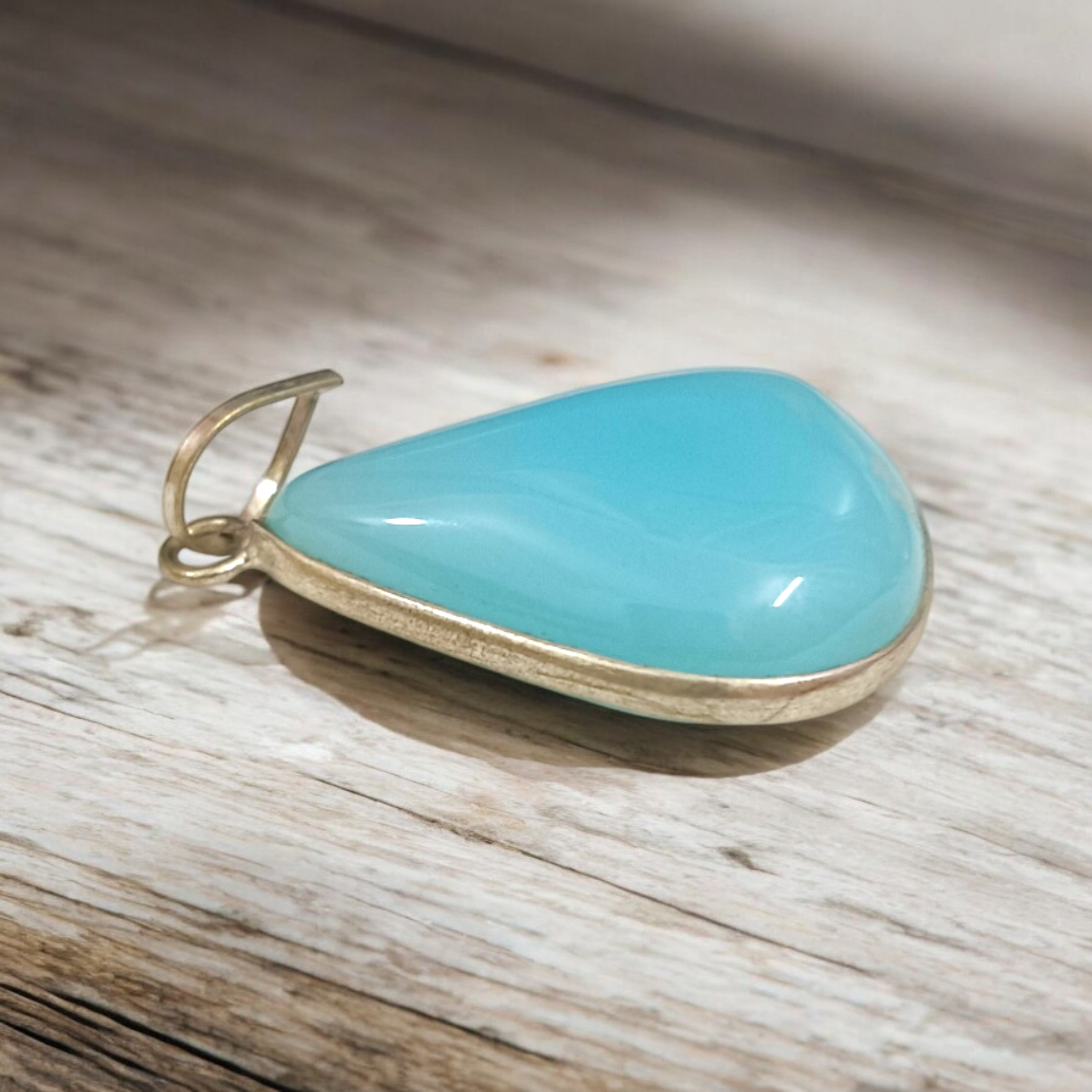 Original Firoza pendant with a vibrant turquoise hue, displayed on a necklace, highlighting its polished finish and elegant design.
