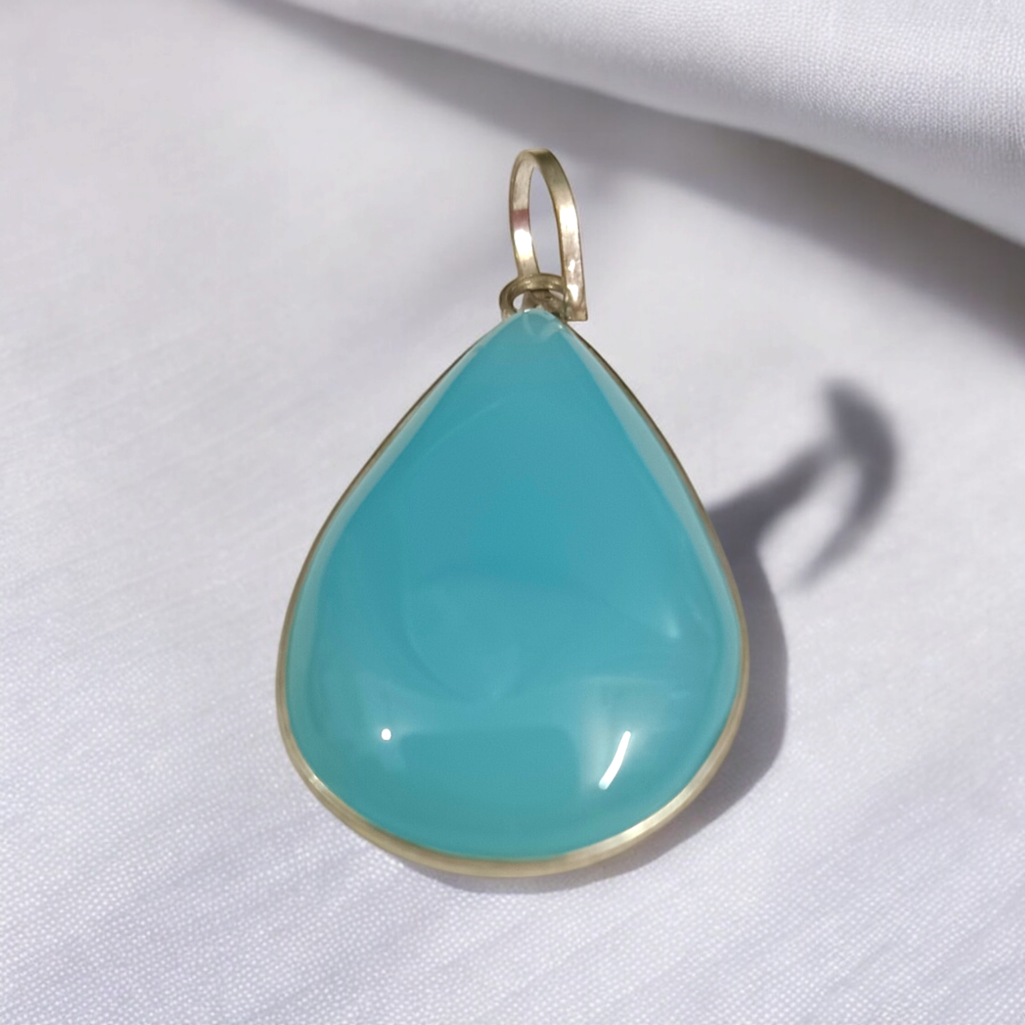 Original Firoza pendant with a vibrant turquoise hue, displayed on a necklace, highlighting its polished finish and elegant design.