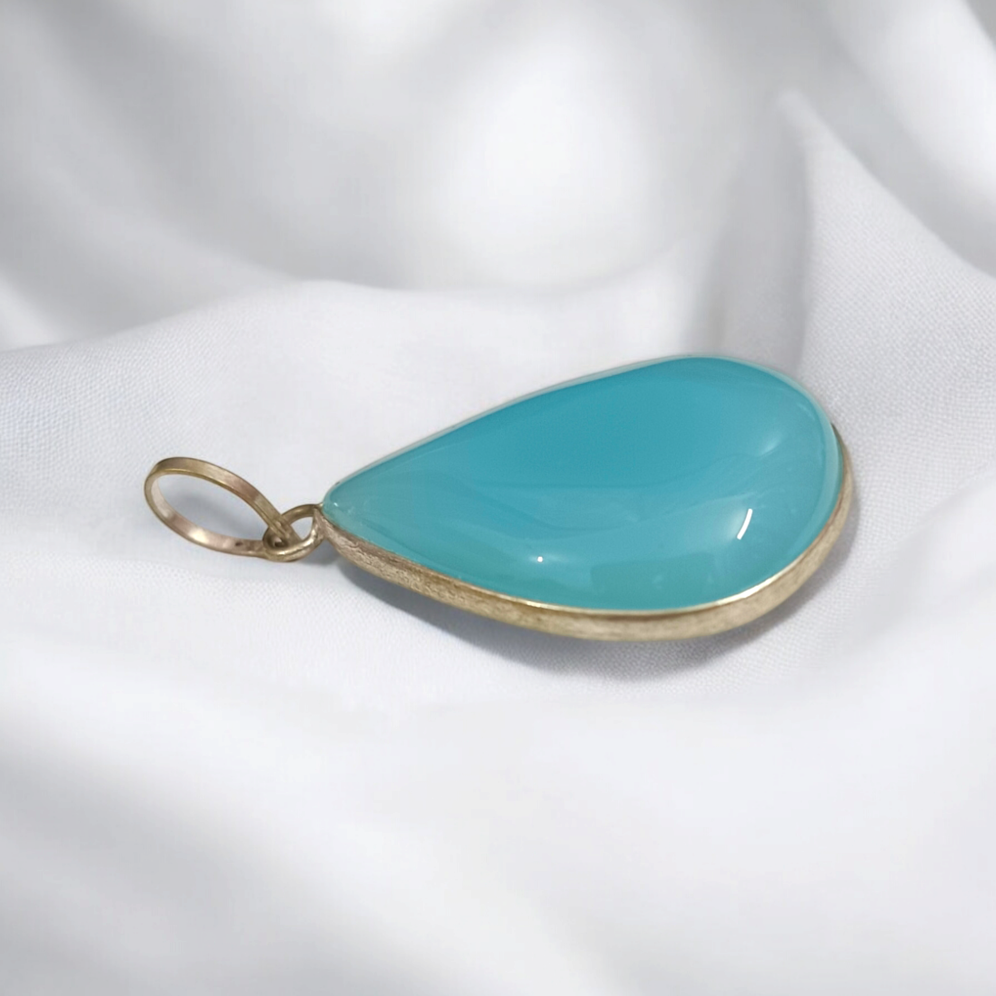 Original Firoza pendant with a vibrant turquoise hue, displayed on a necklace, highlighting its polished finish and elegant design.