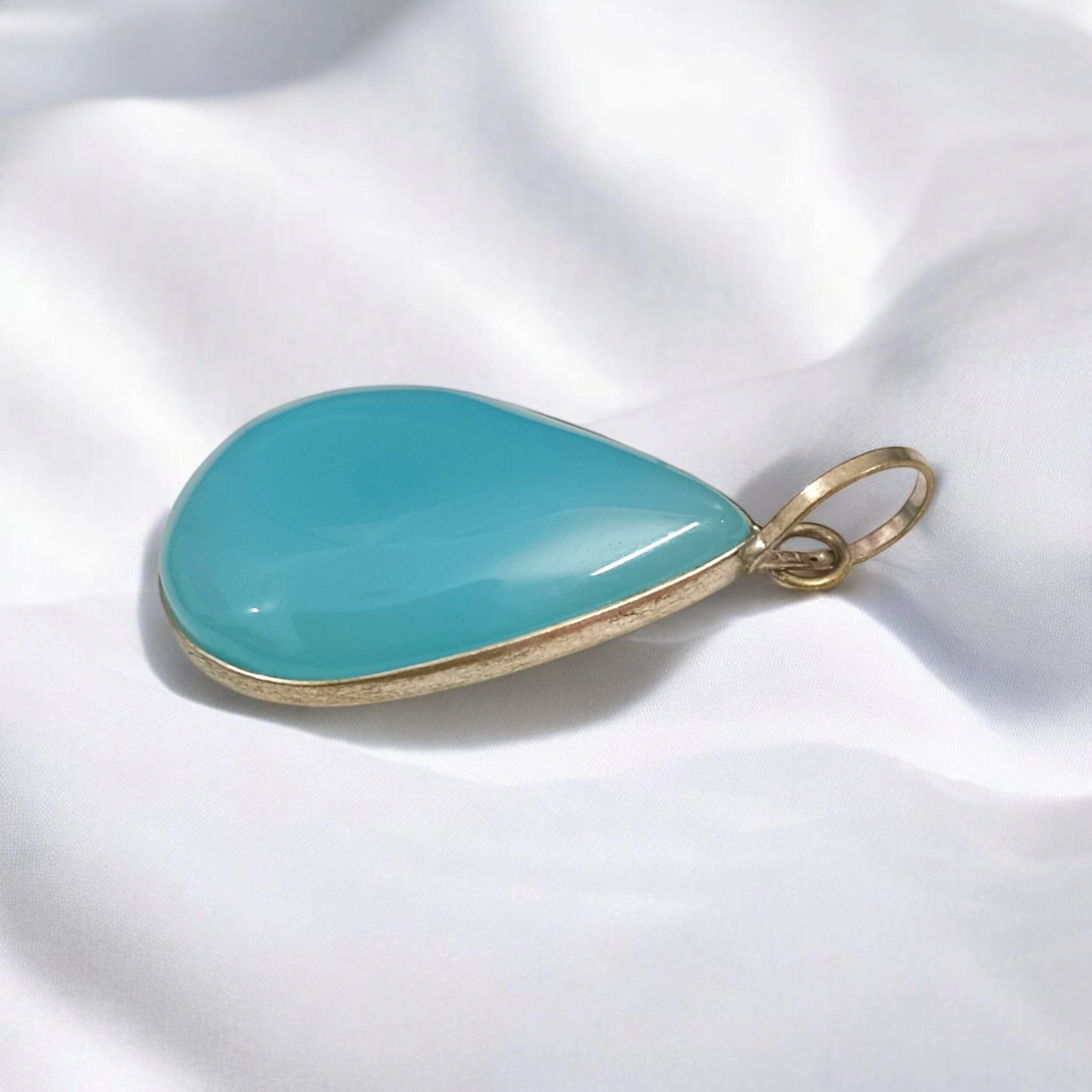 Original Firoza pendant with a vibrant turquoise hue, displayed on a necklace, highlighting its polished finish and elegant design.
