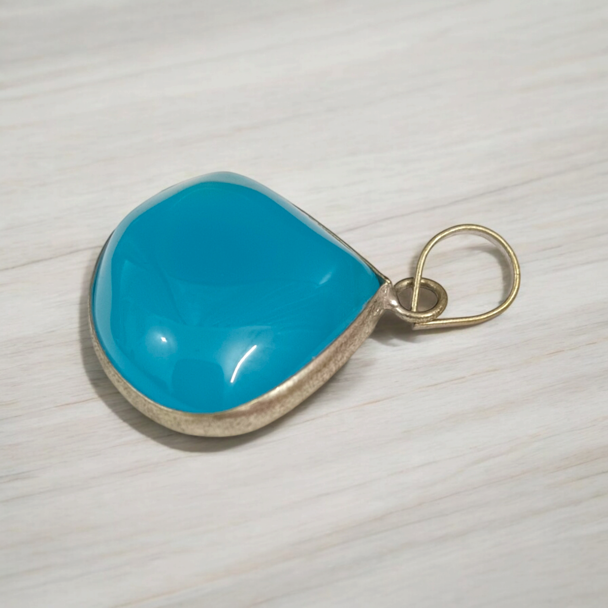 Original Firoza pendant with a vibrant turquoise hue, displayed on a necklace, highlighting its polished finish and elegant design.
