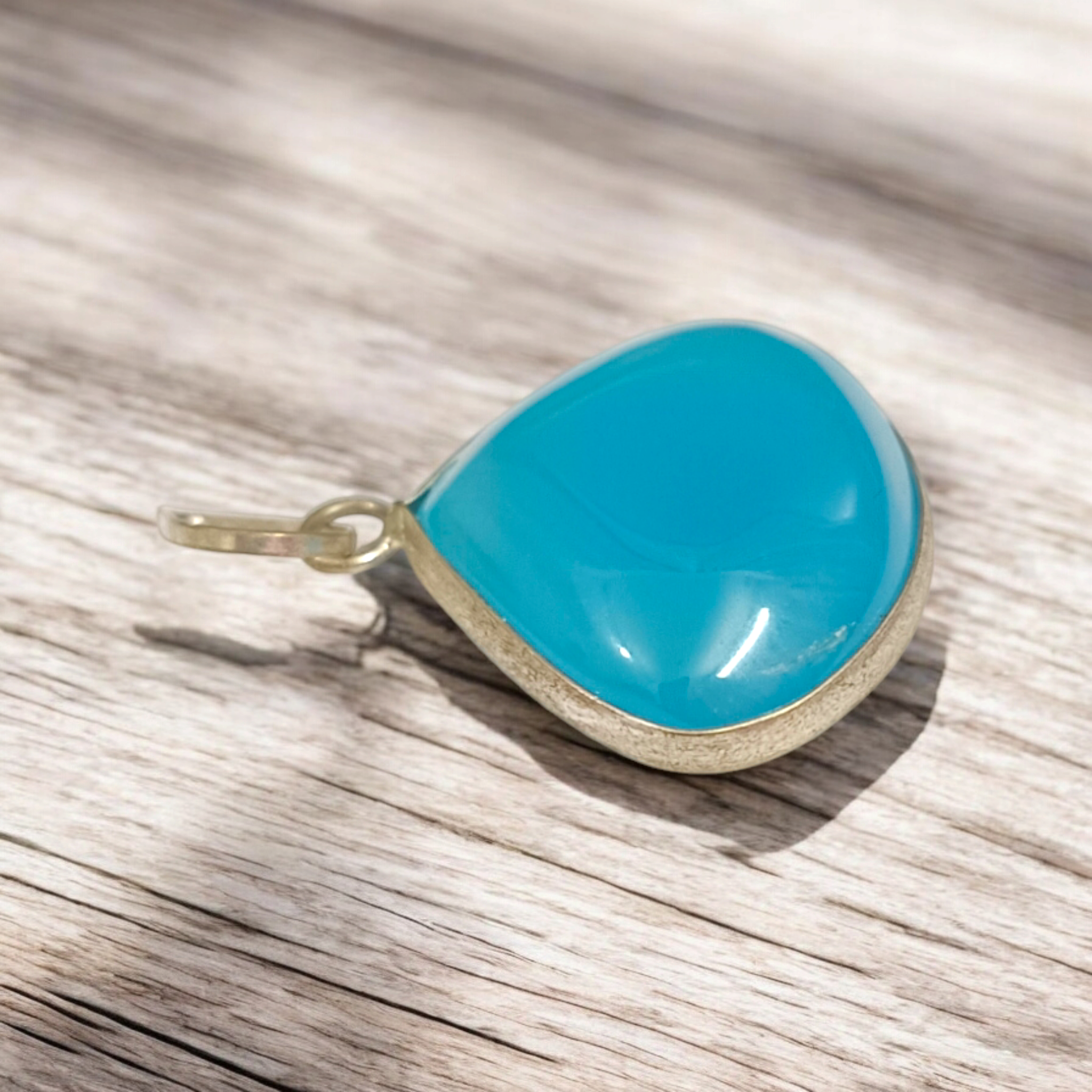 Original Firoza pendant with a vibrant turquoise hue, displayed on a necklace, highlighting its polished finish and elegant design.