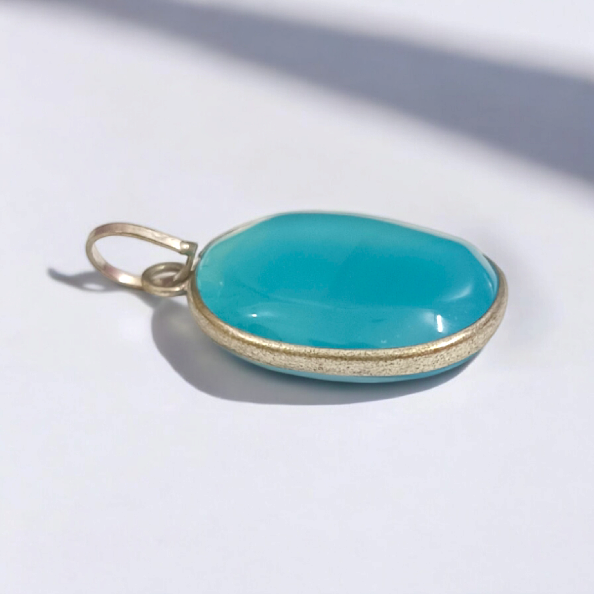 Original Firoza pendant with a vibrant turquoise hue, displayed on a necklace, highlighting its polished finish and elegant design.
