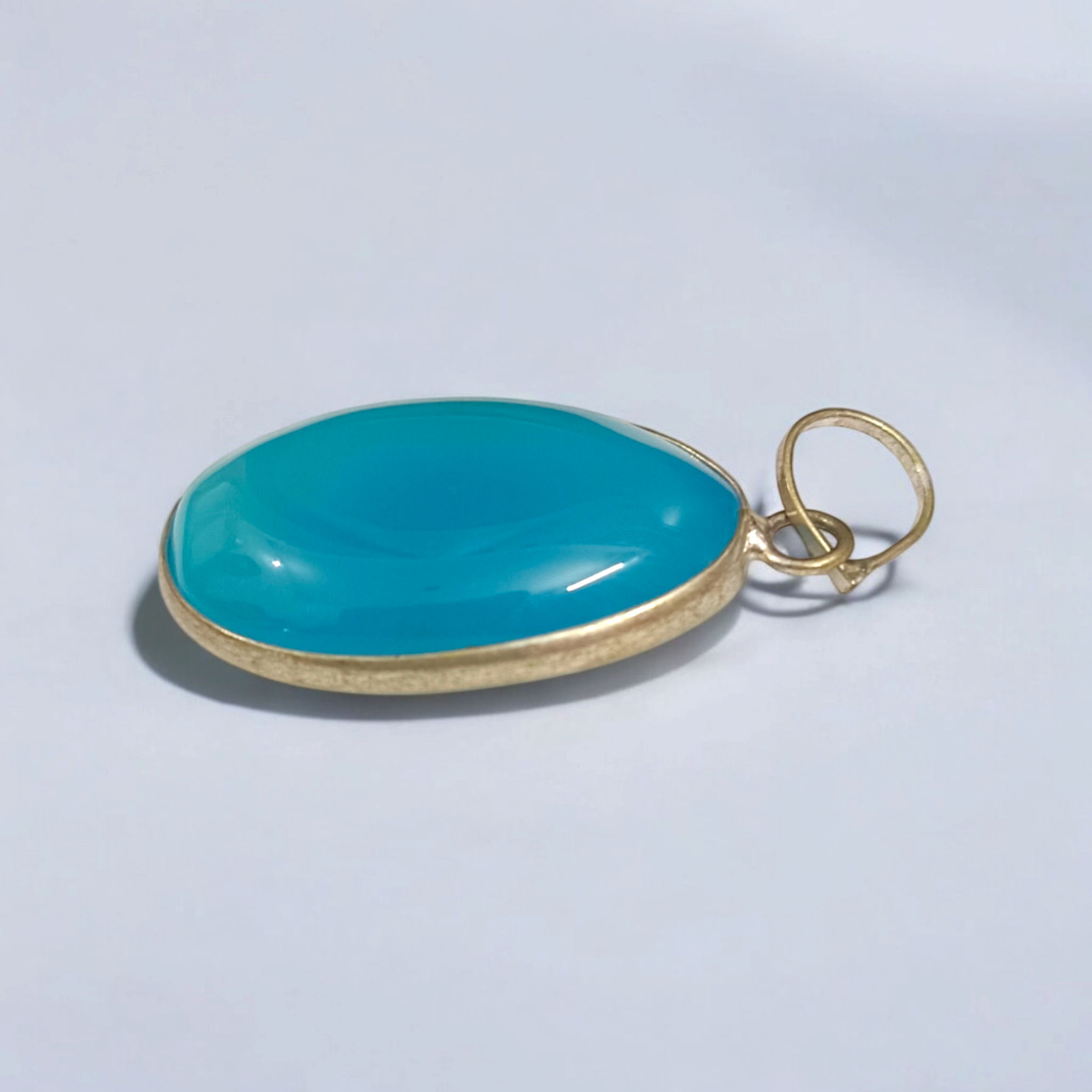Original Firoza pendant with a vibrant turquoise hue, displayed on a necklace, highlighting its polished finish and elegant design.