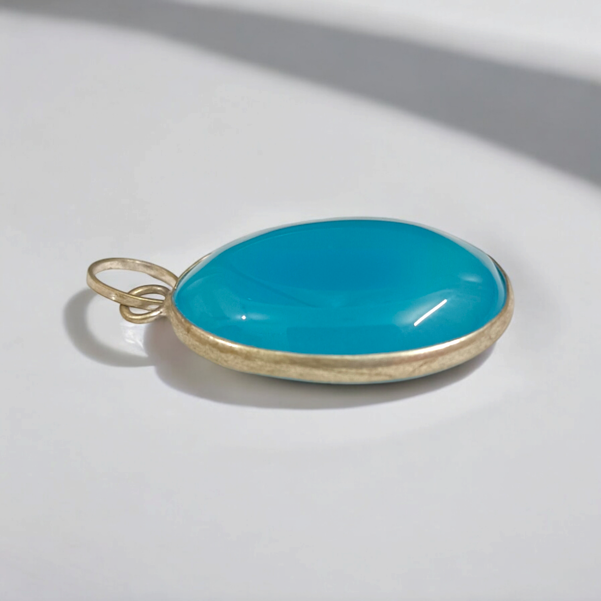 Original Firoza pendant with a vibrant turquoise hue, displayed on a necklace, highlighting its polished finish and elegant design.