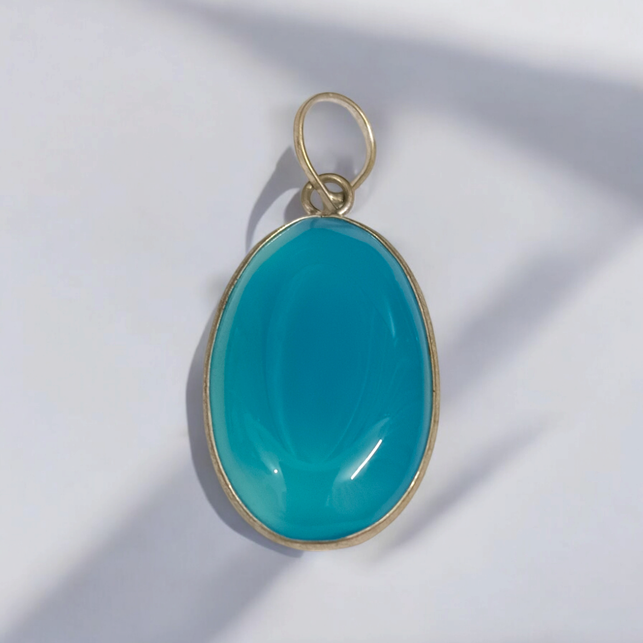 Original Firoza pendant with a vibrant turquoise hue, displayed on a necklace, highlighting its polished finish and elegant design.