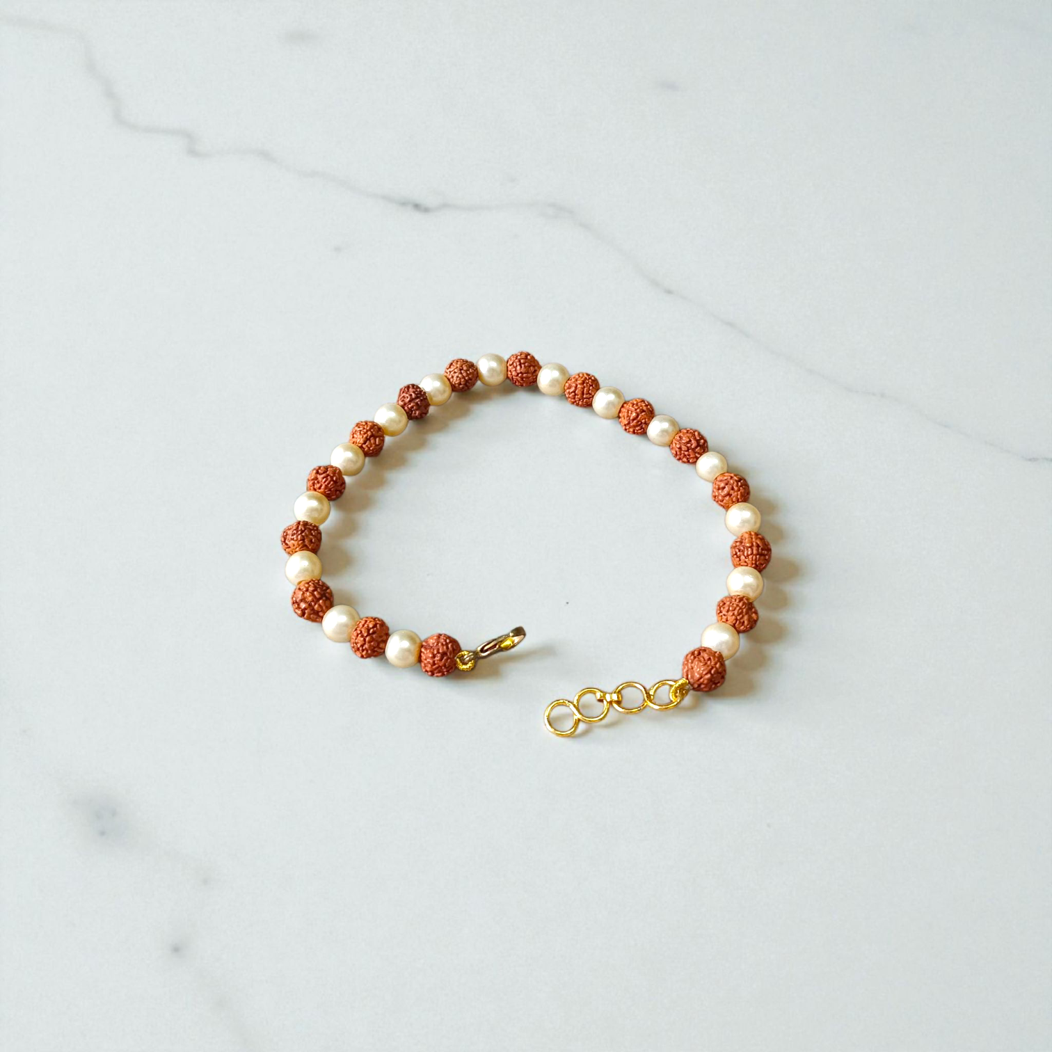 Rudraksha and Moti (Pearl) Bracelet with elegant design, stretchable, placed on a spiritual fabric background