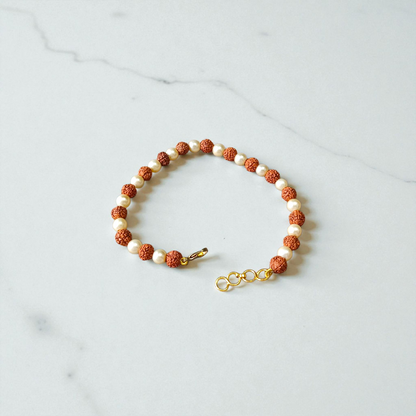 Rudraksha and Moti (Pearl) Bracelet with elegant design, stretchable, placed on a spiritual fabric background