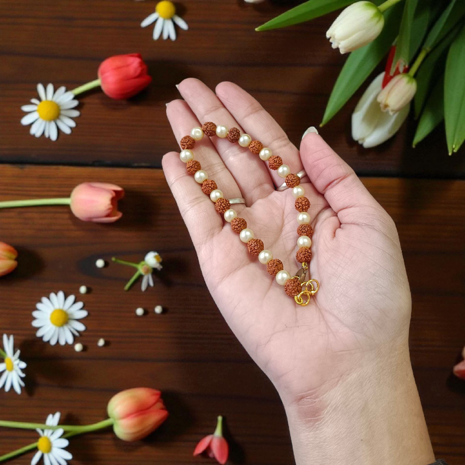 Rudraksha and Moti (Pearl) Bracelet with elegant design, stretchable, placed on a spiritual fabric background