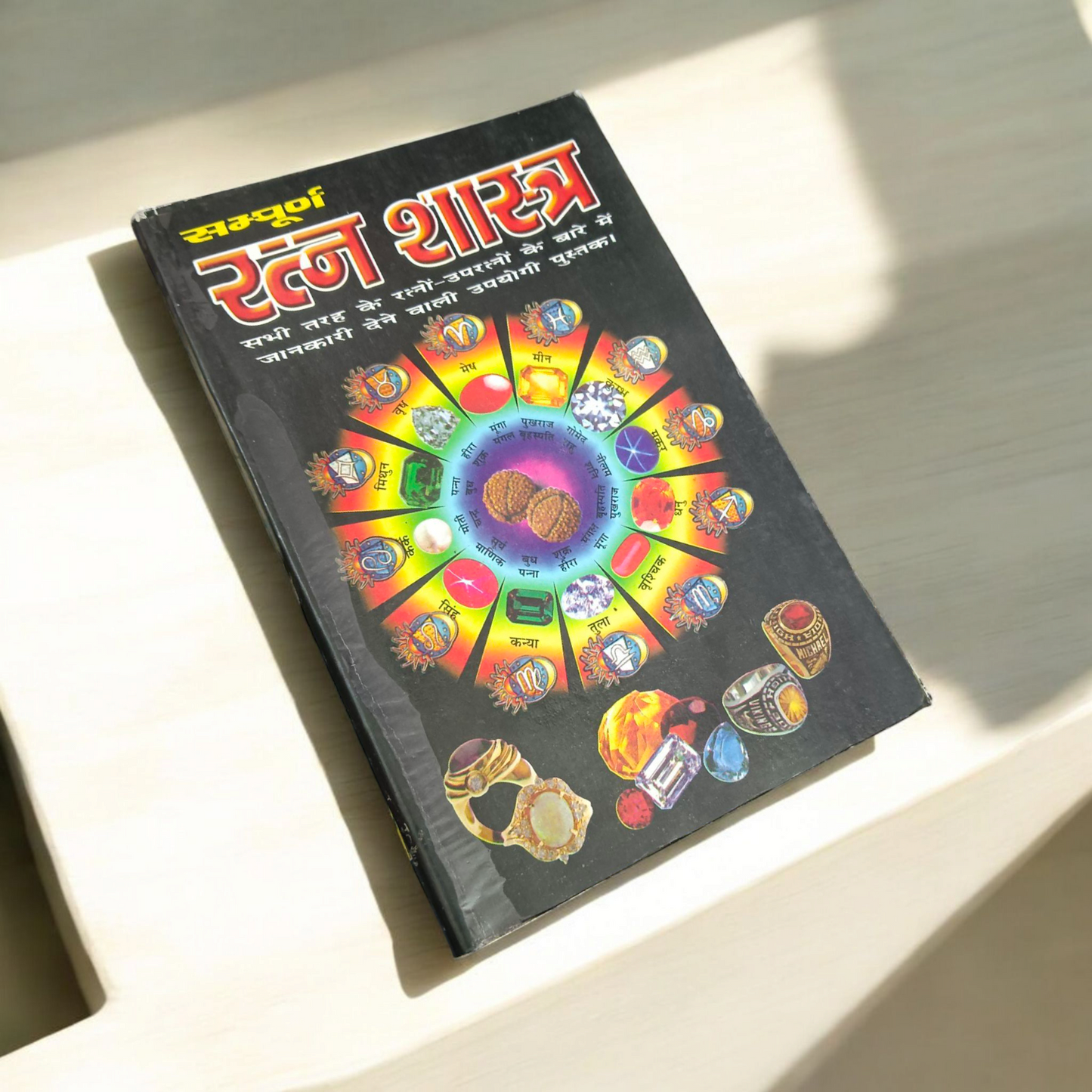 The Ratan Shastra book displayed with various gemstones around it, symbolizing the spiritual and healing properties of gemstones in Vedic astrology.
