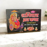 The Shaniwar Vrat Katha book, with an image of Lord Shani and symbols representing the planet Saturn, surrounded by spiritual motifs and prayer beads.
