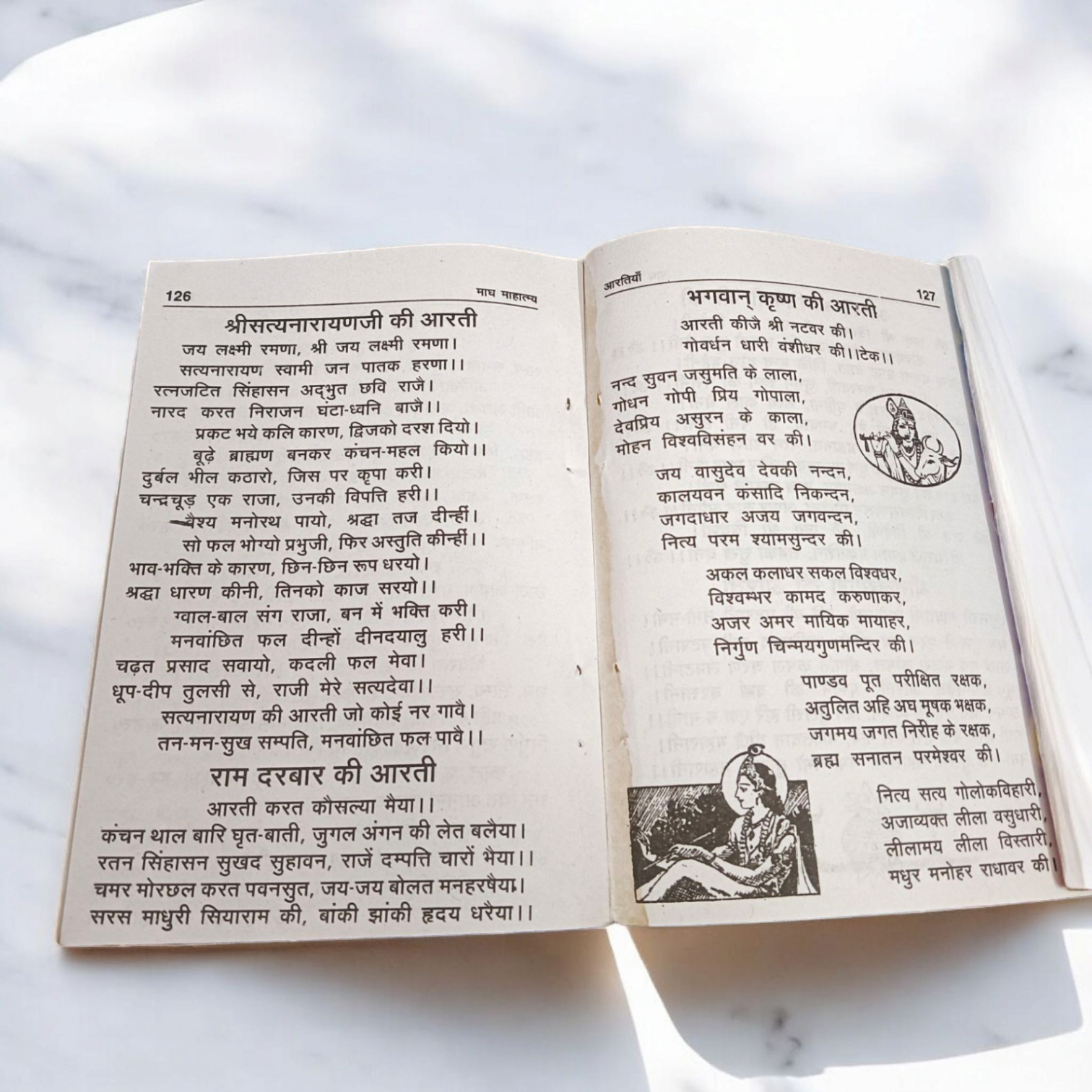 The image displays the cover of Magh Mahatmya | Hindi Book, featuring sacred symbols associated with the Magh month and the deities worshipped during this time.