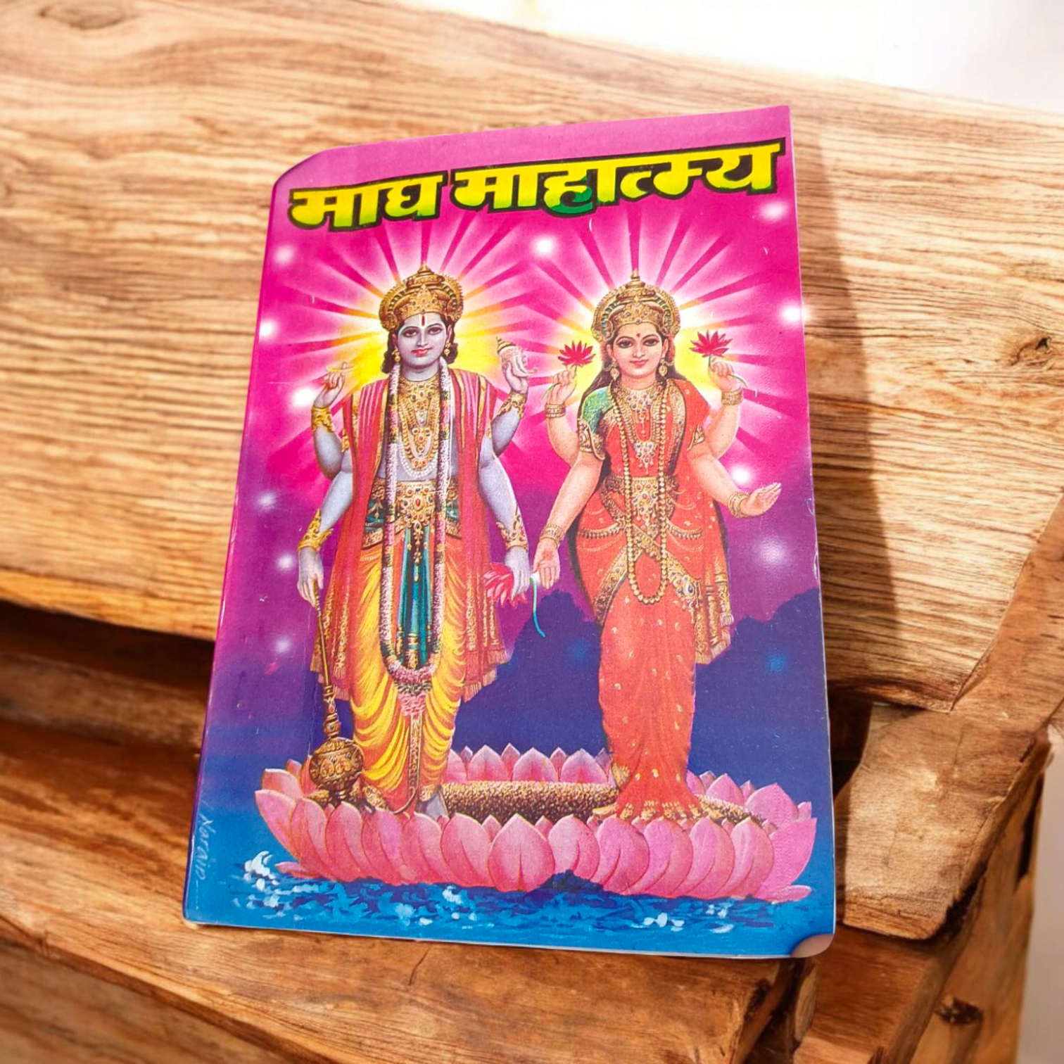 The image displays the cover of Magh Mahatmya | Hindi Book, featuring sacred symbols associated with the Magh month and the deities worshipped during this time.