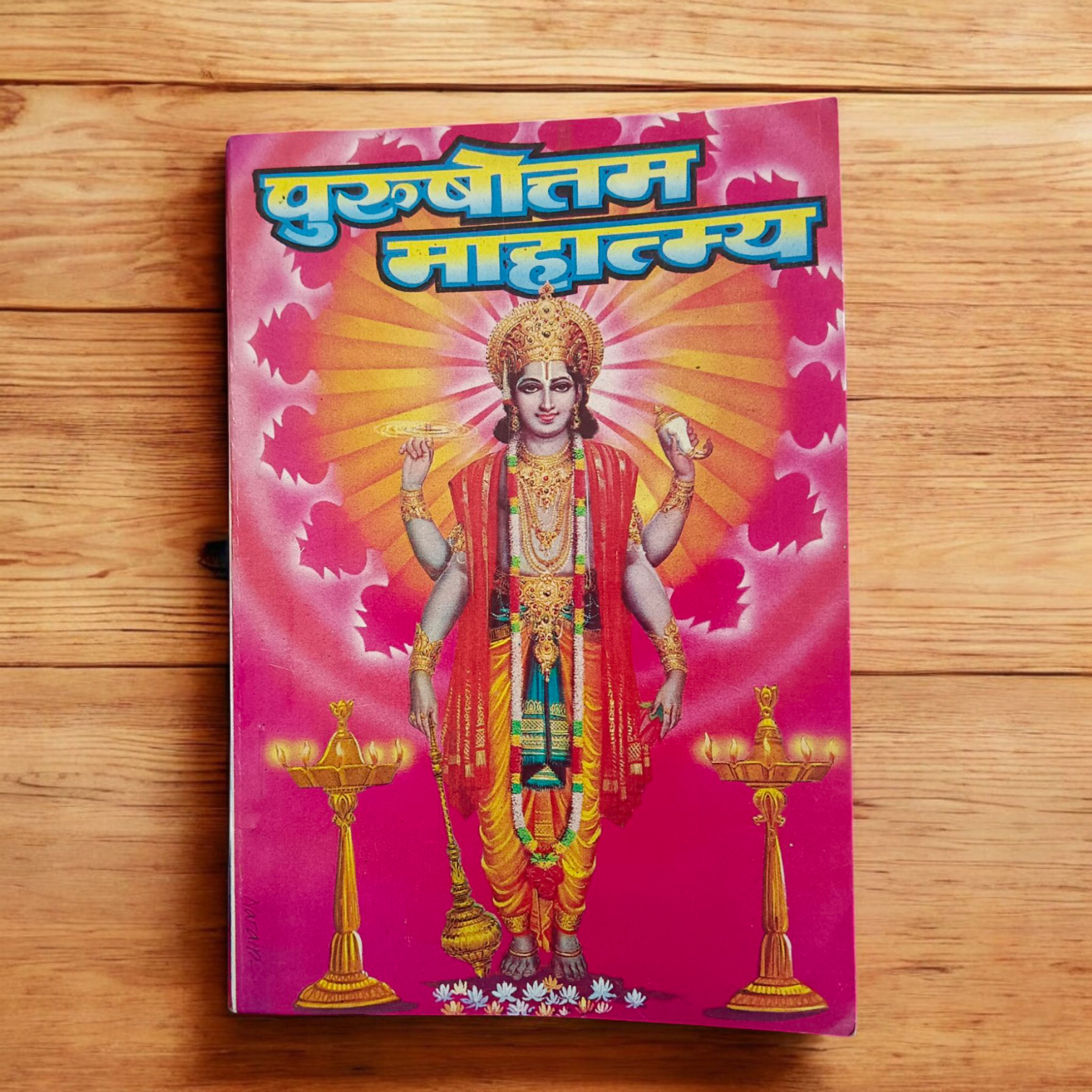 The image shows the cover of Purushottamm Mahatmya | Hindi Book, featuring vibrant and sacred symbols related to Lord Vishnu and Purushottam month rituals.