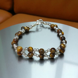 Tiger Eye Bracelet made of natural 7mm lab-certified beads with golden-brown tones placed on a white background